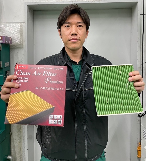 エアコンフィルターを持つサービススタッフの日下部